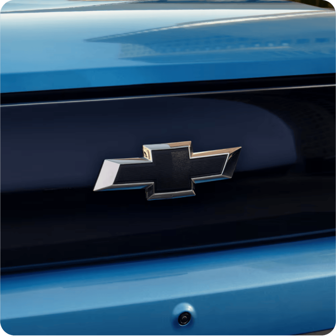 Emblema Chevrolet destacado sobre carrocería azul, símbolo de calidad y confianza