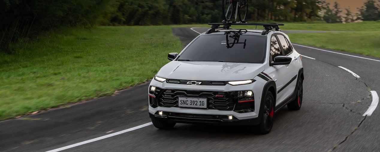 Chevrolet Sonic circulando por una ruta equipado con un porta bicicleta.