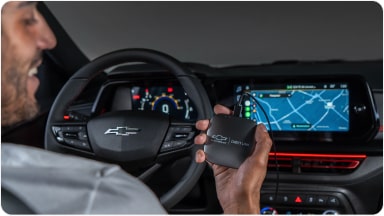Persona sosteniendo el módulo de entretenimiento Chevy Link.