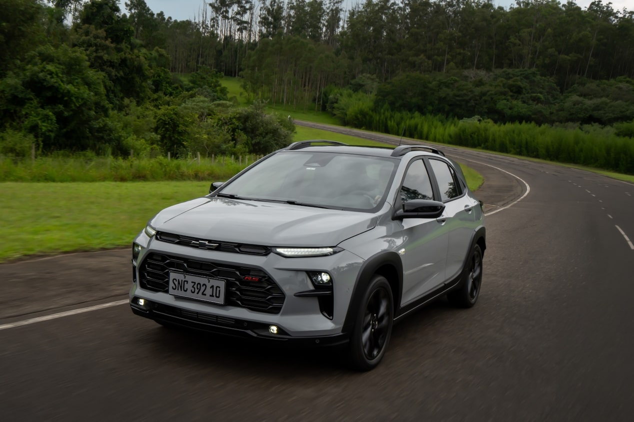 Un Chevrolet Sonic circulando en un ruta rodeada de naturaleza.