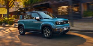 Spark EUV Azul Atlântico rodand por uma rua residencial, com faróis acesos e estilo marcante.