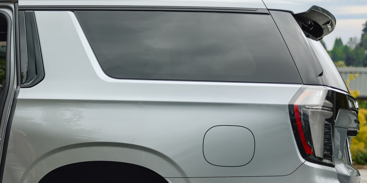 Vista lateral posterior de la Chevrolet Suburban Z71 color plata, destacando el diseño de la ventana y luces traseras