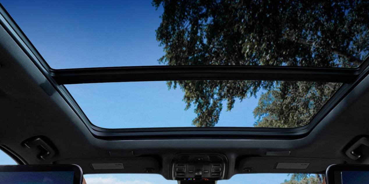Vista interior del sunroof panorámico de la Chevrolet Suburban Z71 con cielo despejado