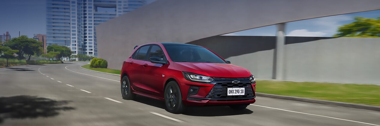 Chevrolet Onix conduciendo en ruta urbana.