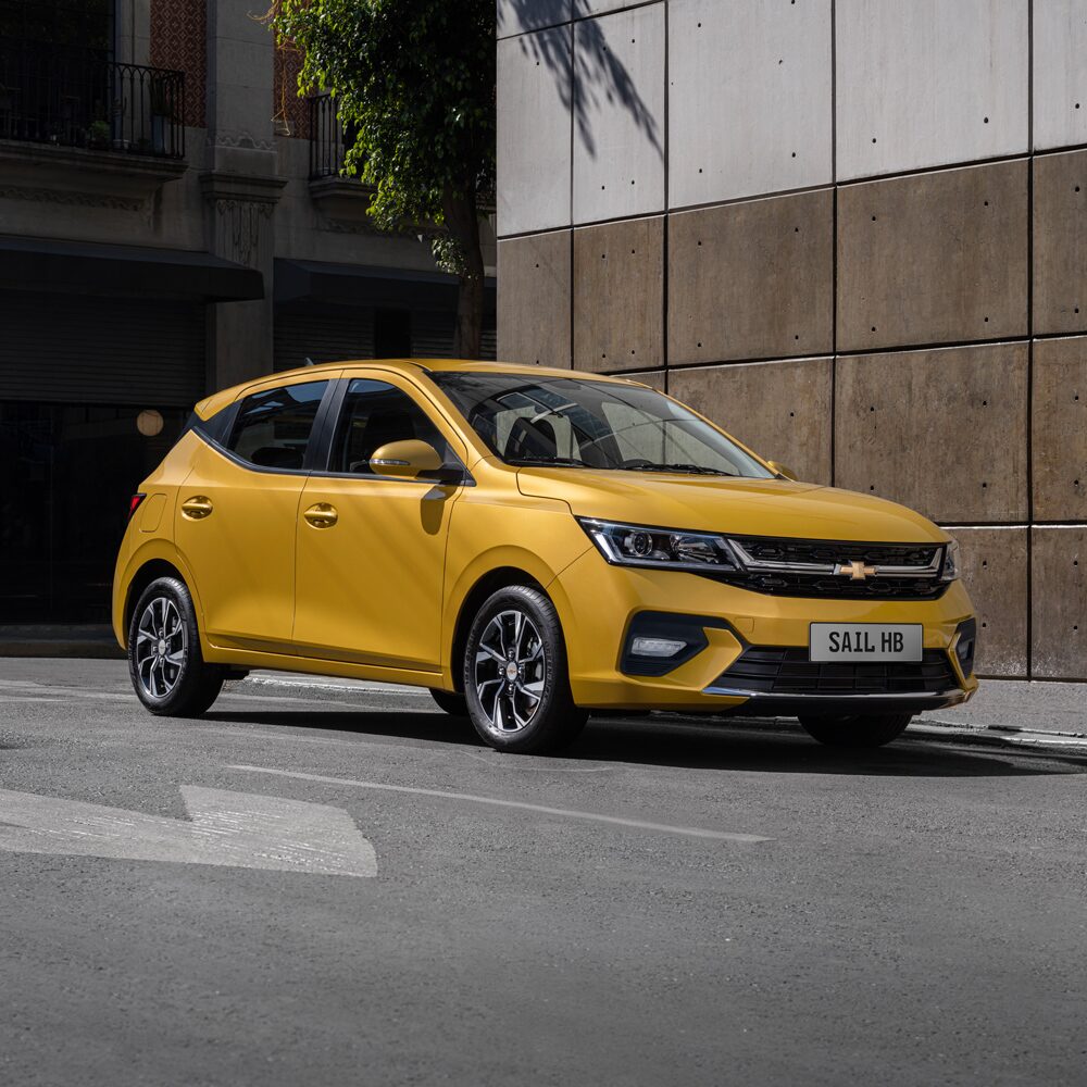 Chevrolet Sail HB color Amarillo estacionado en la calle.