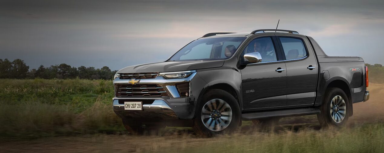 Chevrolet Colorado estacioanada en el campo sobre un pastizal.