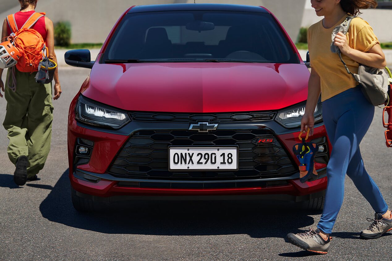 Vista frontal del Chevrolet Onix con gente caminando cerca.