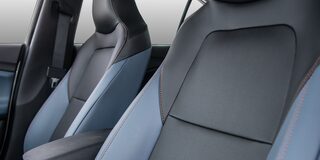 Interior del Chevrolet Onix Sedán Premier AT, destacando los asientos delanteros con detalles en color azul y gris de ecocuero premium.