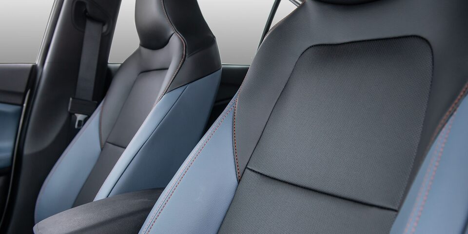 Interior del Chevrolet Onix Sedán Premier AT, destacando los asientos delanteros con detalles en color azul y gris de ecocuero premium.