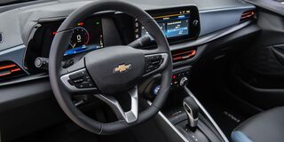 Interior del Chevrolet Onix Sedán Premier AT, mostrando el volante, el tablero digital y la pantalla central táctil con detalles en color azul y gris de ecocuero premium.