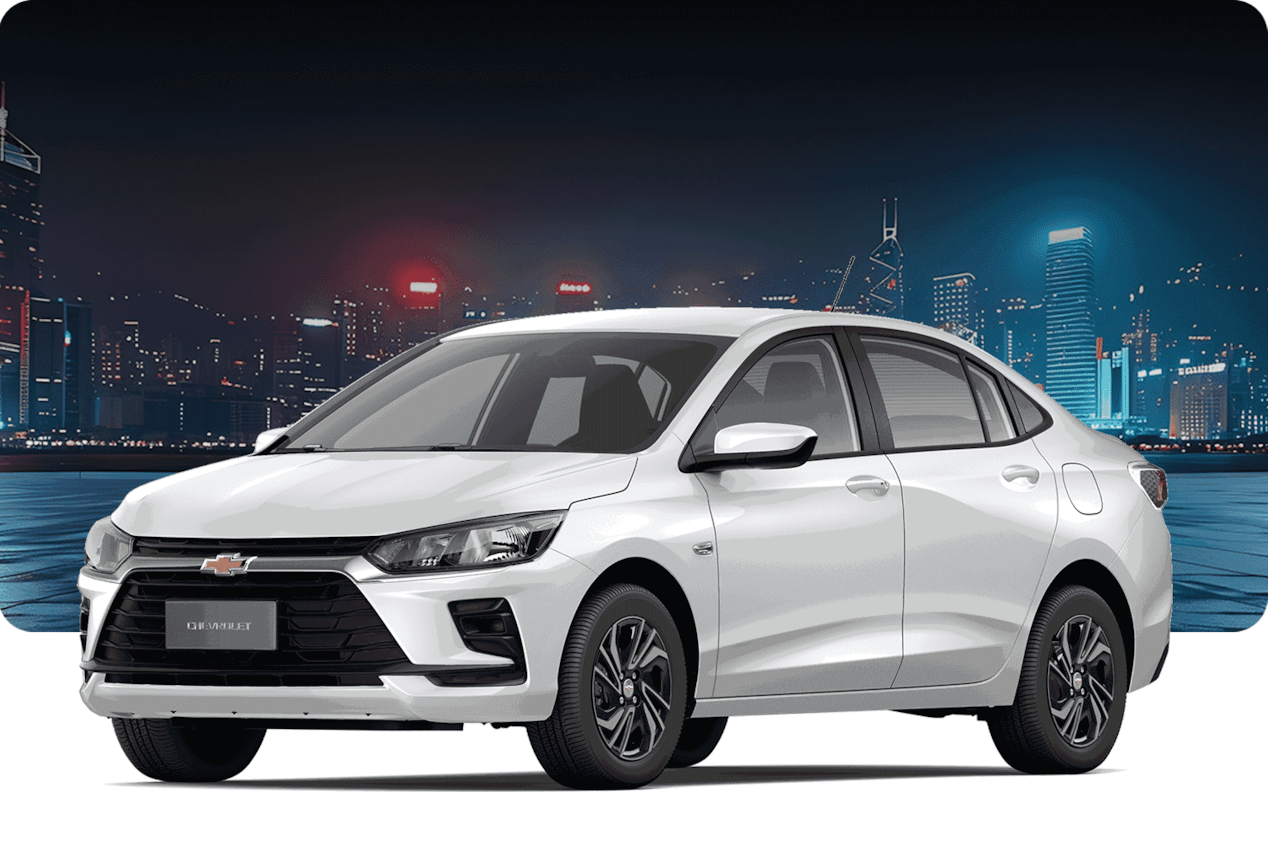 Chevrolet Onix Sedán versión LT MT sobre un fondo urbano con edificios de noche. 