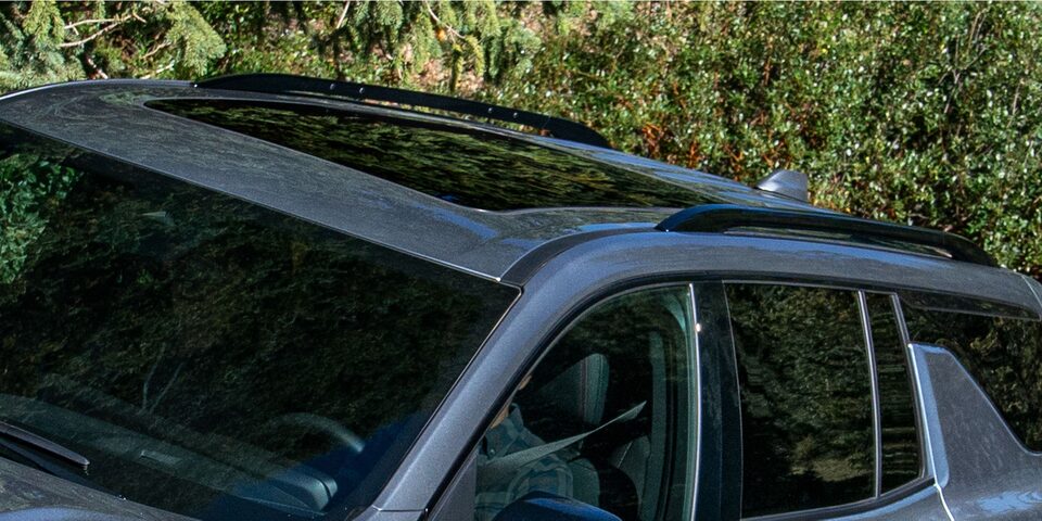 Detalle del techo de la Chevrolet Traverse Z71 con barras portaequipaje negras, visto desde arriba, con vegetación verde de fondo.