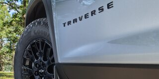 Vista en detalle de la insignia Traverse en la parte inferior izquierda del vehículo, junto a la llanta bitono.
