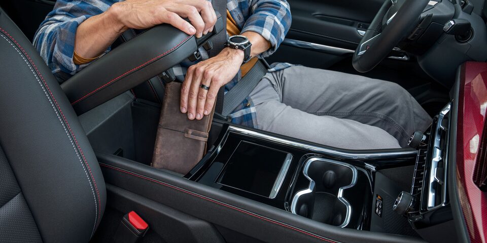 Detalle del interior de la Chevrolet Traverse Z71 mostrando la consola central con portavasos, selector de cambios y apoyabrazos, en un diseño moderno y funcional.