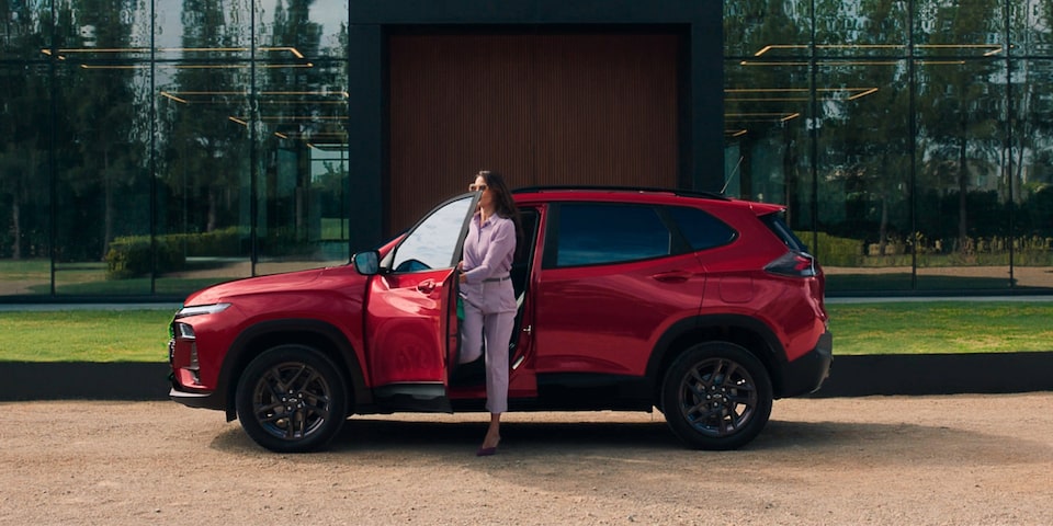 Mujer bajando de una Chevrolet Tracker color Rojo Fuego estacionada.