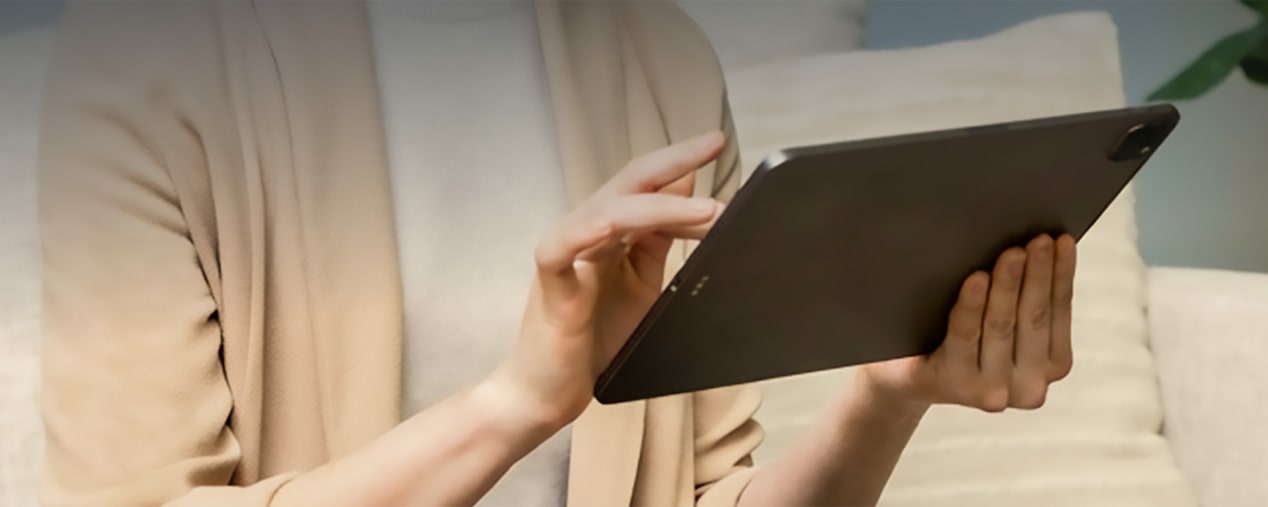 Imagen del torso de una mujer mientras utiliza un I Pad. 