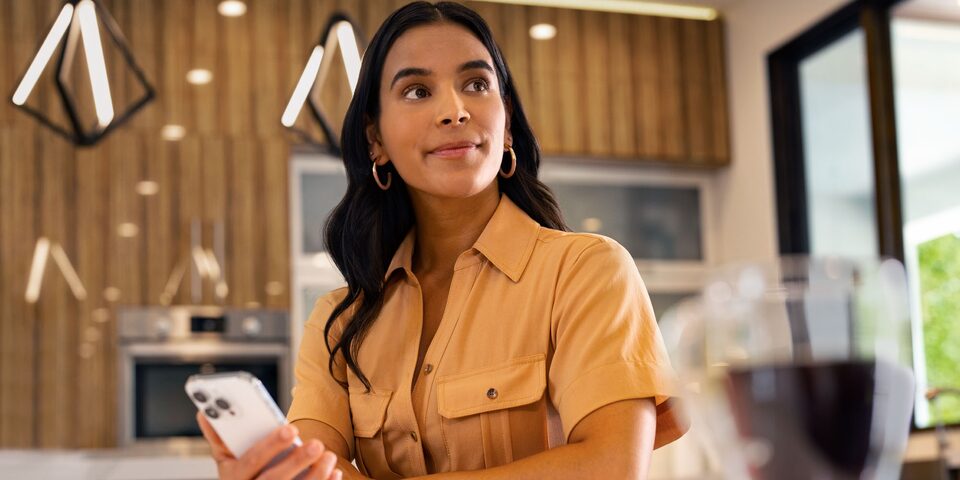 Mujer usando aplicación móvil de Chevrolet para controlar funciones de su vehículo desde casa