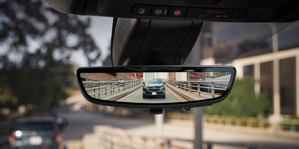 Vista desde el espejo retrovisor con tecnología de seguridad Chevrolet en ciudad