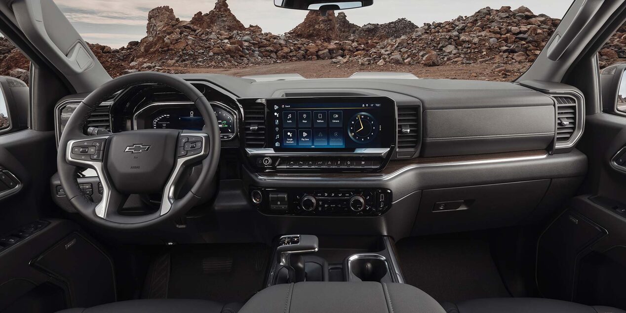 Imagen del interior de una Chevrolet Silverado Z71, mostrando volante, pantalla digital central, guantera y más.