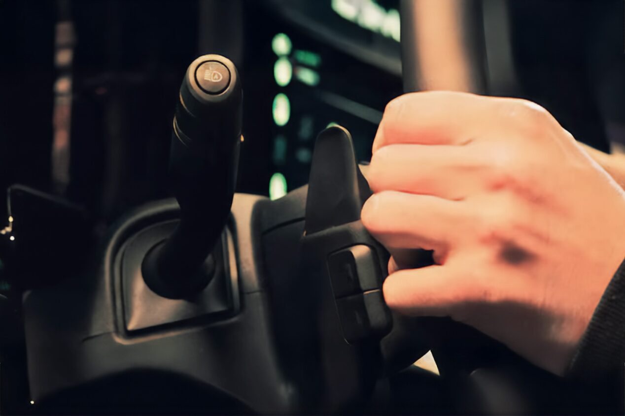 Primer plano de las levas de cambio de la Chevrolet Silverado Z71, mientras una persona sujeta el volante.