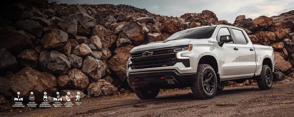 Chevrolet Silverado sobre un camino de ripio, con una pared de rocas atrás.