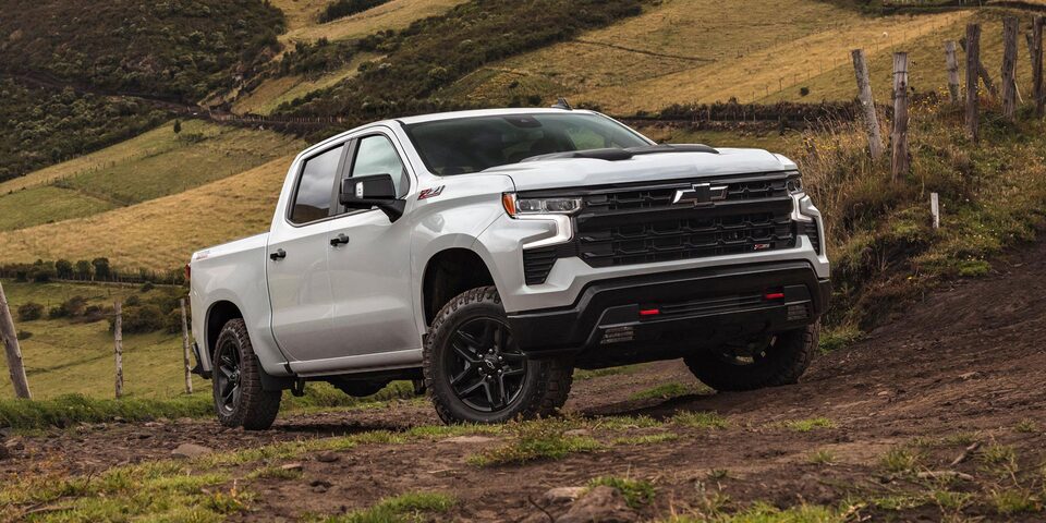 Chevrolet Silverado Z71 estacionada en zona rural, con montañas sierras y árboles de fondo.