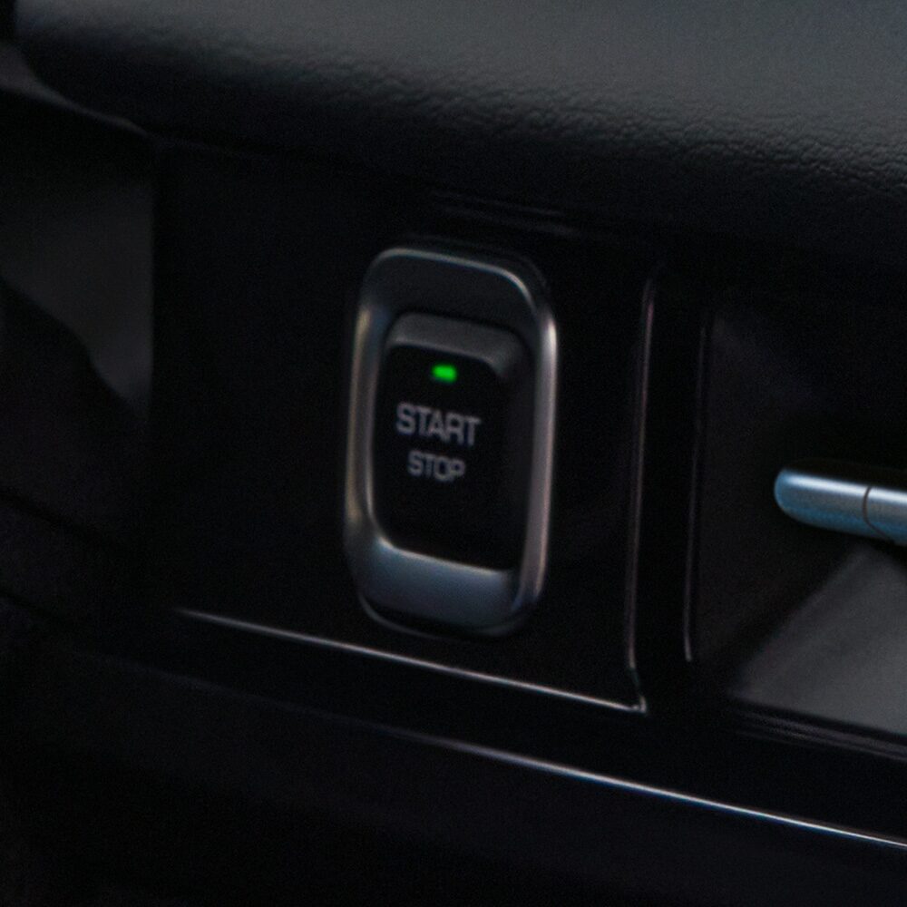 Botón de encendido sin llave de la Chevrolet Groove, con una luz verde encendida en su parte superior y las palabras START y STOP.