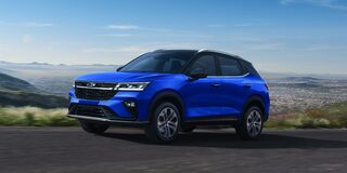 Chevrolet Groove en una carretera panorámica sobre la cima de un mirador. De fondo se pueden ver casas y montes a la distancia. 