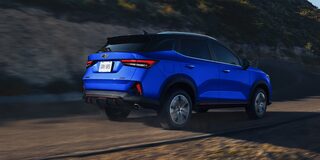 Chevrolet Groove circulando por carretera de tierra sobre un monte, vista desde atrás.