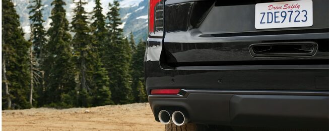 Vista trasera de Chevrolet Tahoe con doble escape en un entorno natural de montaña, destacando diseño deportivo y espíritu aventurero SUV