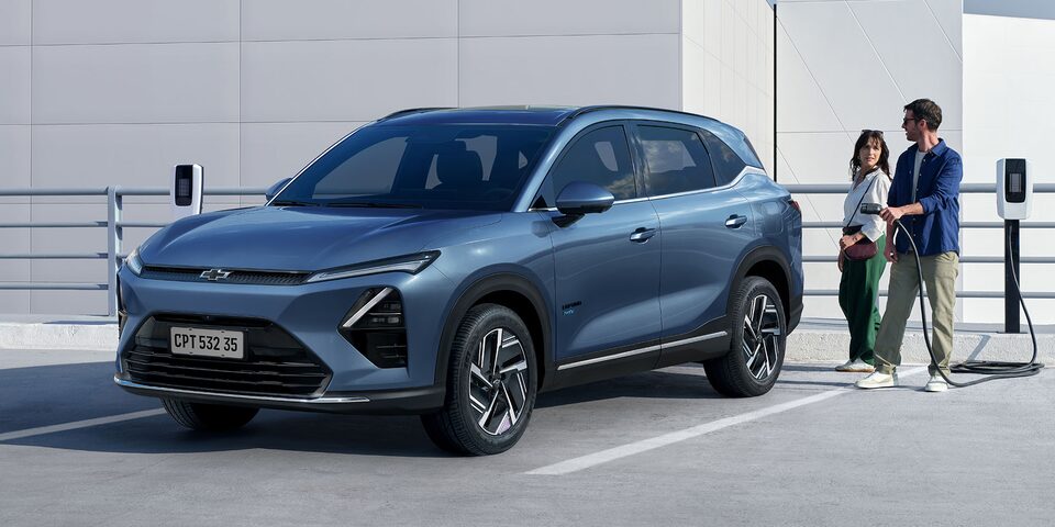Chevrolet Captiva PHEV estacionada con una pareja a punto de poner a cargarla.