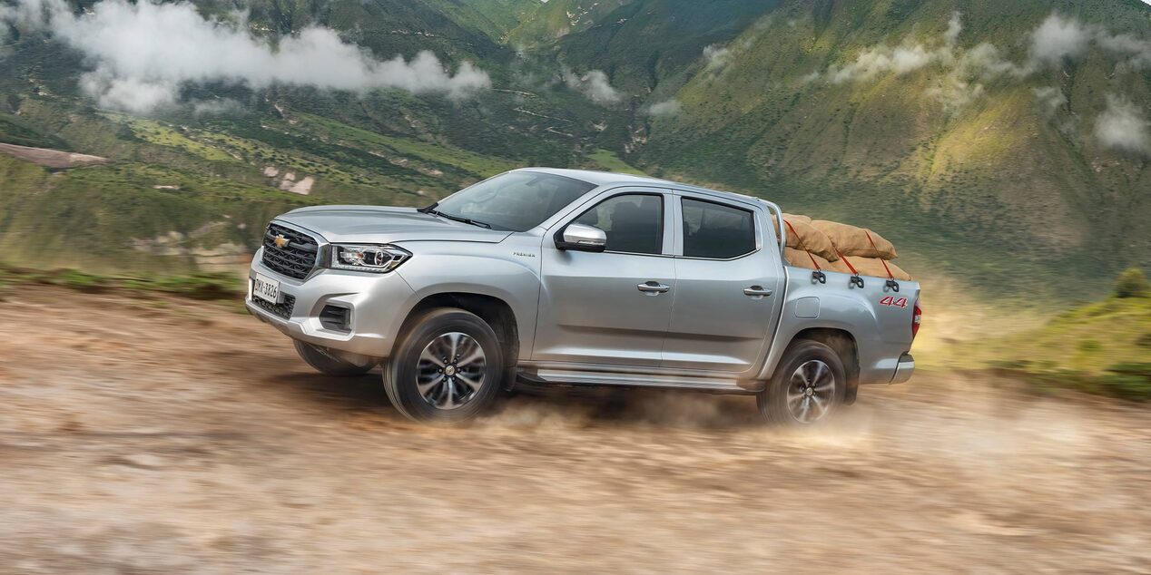 Chevrolet D-Max llevando carga por un camino de tierra.